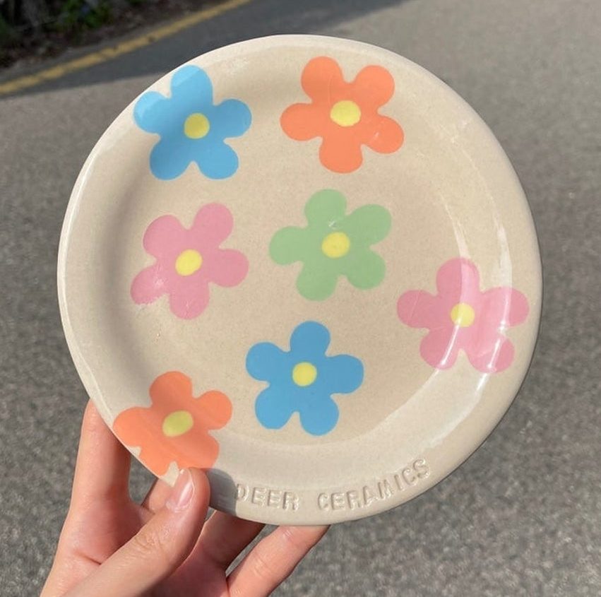 가장자리에 DEER CERAMICS 글자가 찍힌 꽃무늬 완성 접시